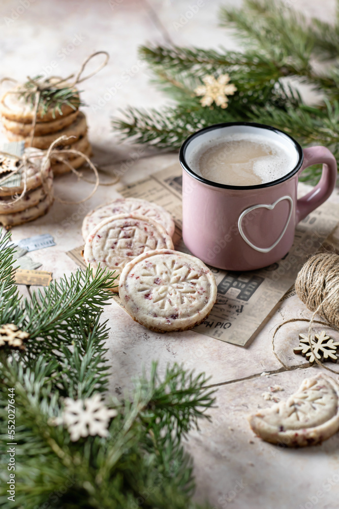 Fresh baked cranberry cookies with cup of coffee . Christmas decoration with fir branches, beige tile background Fresh baked cranberry cookies with cup of coffee . Christmas decoration with fir branches, beige tile background