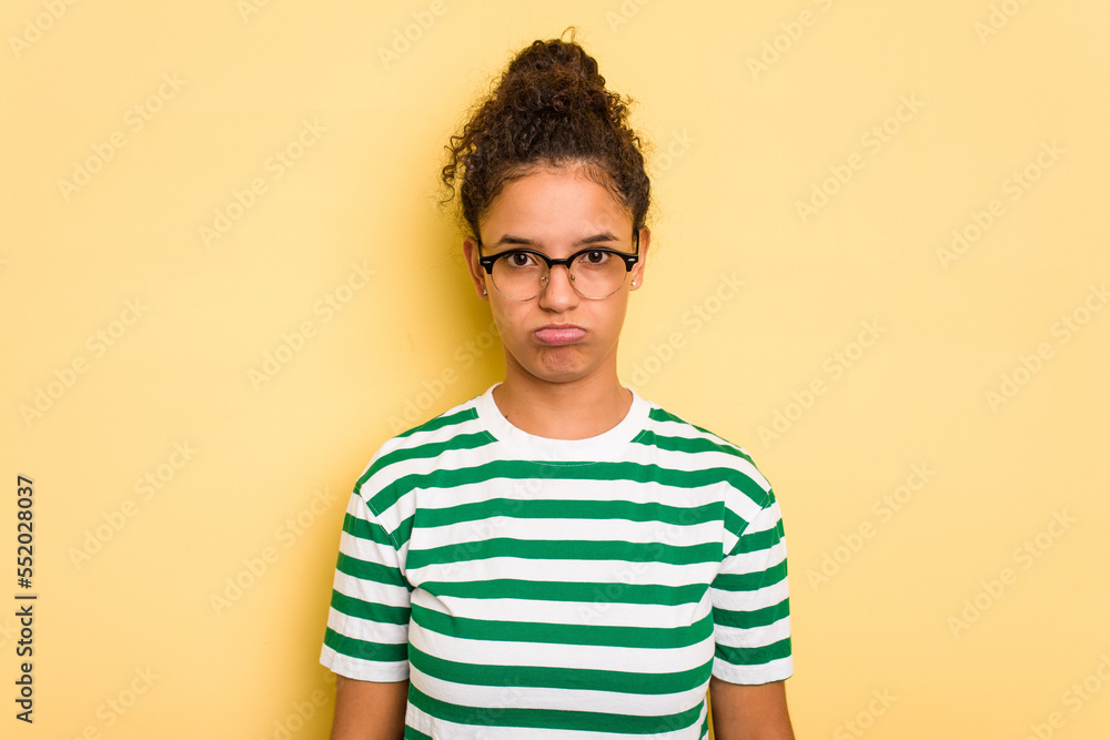 Young Brazilian curly hair cute woman isolated on yellow background sad, serious face, feeling miserable and displeased. Young Brazilian curly hair cute woman isolated on yellow background sad, serious face, feeling miserable and displeased.