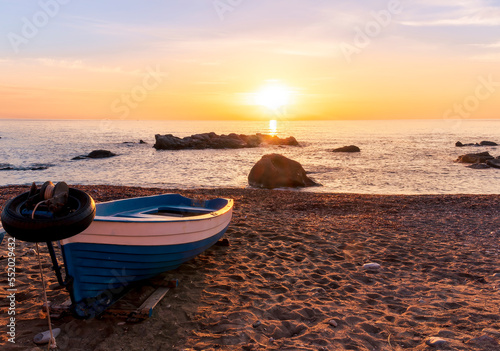 nice old vintage boat on a sea coast with picturesque view on a sunrise in a rocky gulf