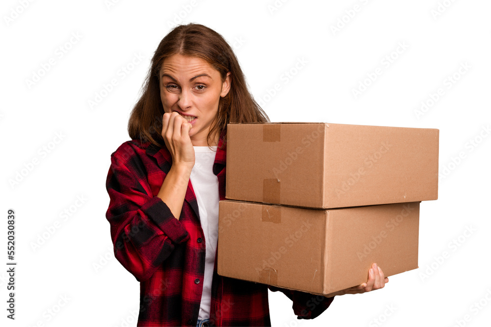 Young caucasian woman moving while picking up a box full of things isolated biting fingernails, nervous and very anxious. Young caucasian woman moving while picking up a box full of things isolated biting fingernails, nervous and very anxious.