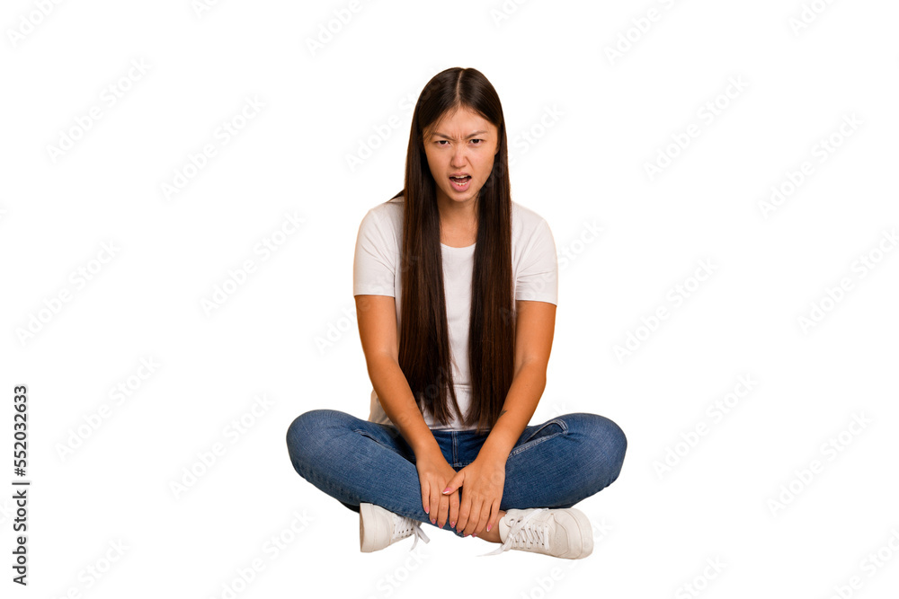 Young asian woman sitting on the floor cutout isolated shouting very angry, rage concept, frustrated. Young asian woman sitting on the floor cutout isolated shouting very angry, rage concept, frustrated.