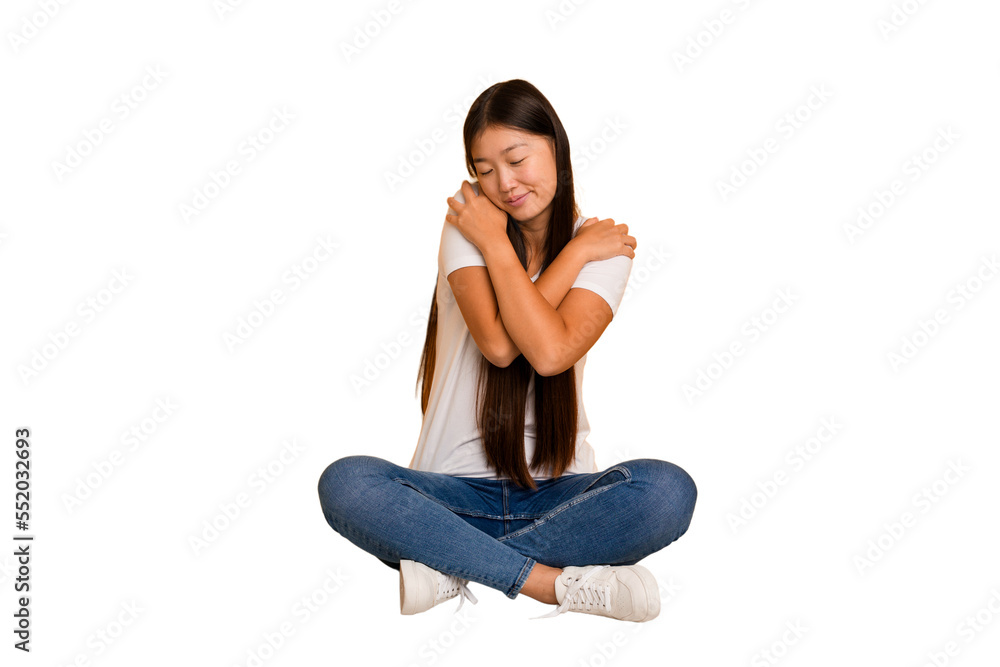 Young asian woman sitting on the floor cutout isolated hugs, smiling carefree and happy. Young asian woman sitting on the floor cutout isolated hugs, smiling carefree and happy.