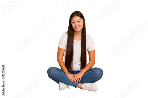 Young asian woman sitting on the floor cutout isolated happy, smiling and cheerful.