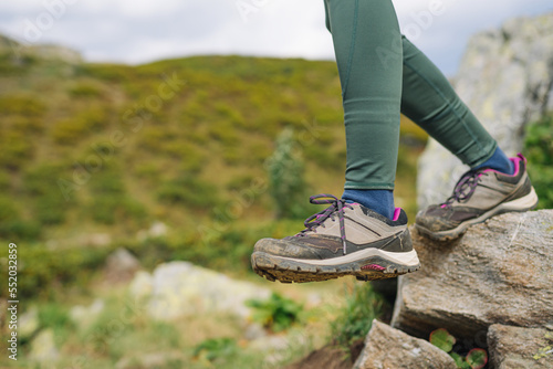 Woman hiker feet walking in rocky mountains, Low angle view