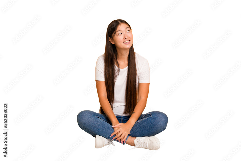 Young asian woman sitting on the floor cutout isolated relaxed and happy laughing, neck stretched showing teeth. Young asian woman sitting on the floor cutout isolated relaxed and happy laughing, neck stretched showing teeth.