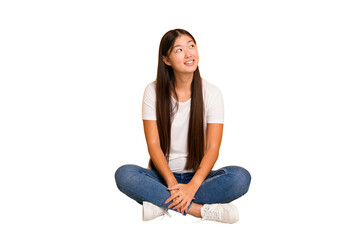 Young asian woman sitting on the floor cutout isolated relaxed and happy laughing, neck stretched showing teeth.