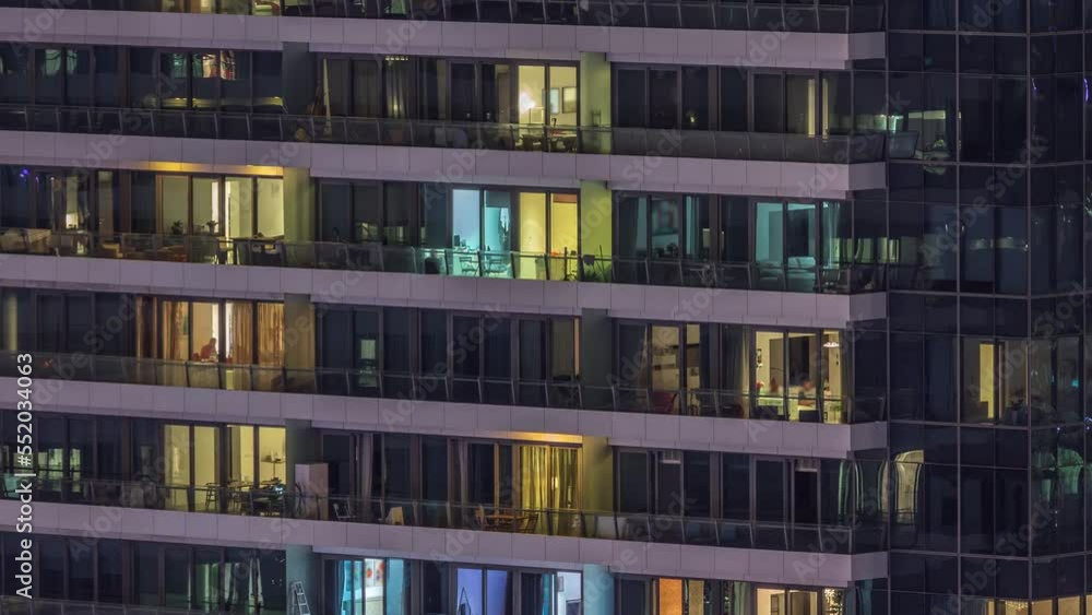 Windows lights in modern residential buildings timelapse at night. Multi-level skyscrapers with illuminated rooms inside Windows lights in modern residential buildings timelapse at night. Multi-level skyscrapers with illuminated rooms inside