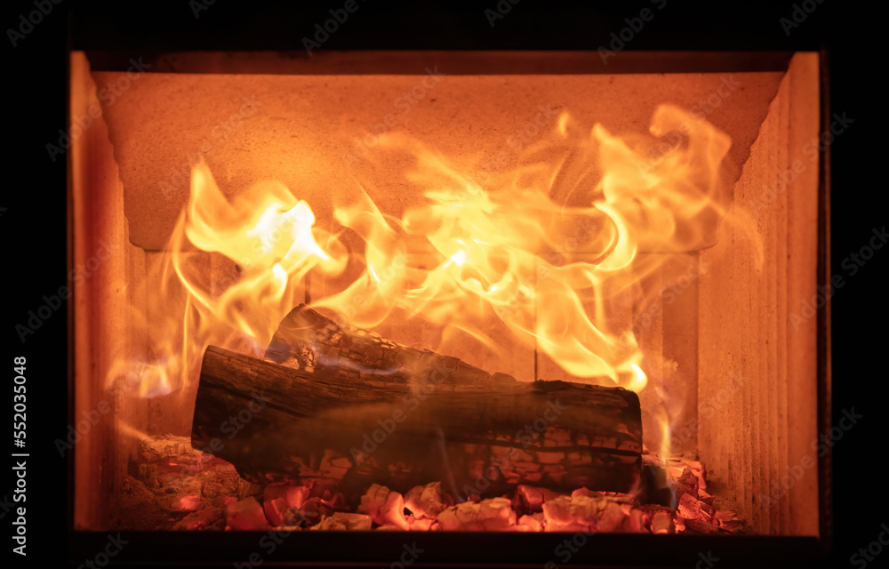 Fototapeta premium Fire flames and burning wood logs, energy stove fireplace close up,
