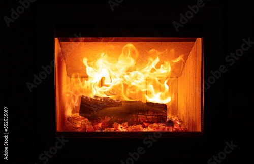 Fire flames and burning wood logs, energy stove fireplace close up,