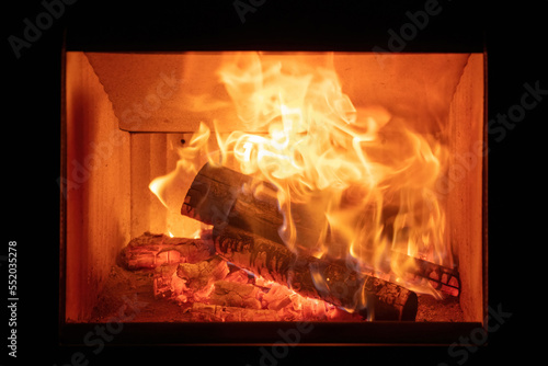 Fire flames and burning wood logs  energy stove fireplace close up 