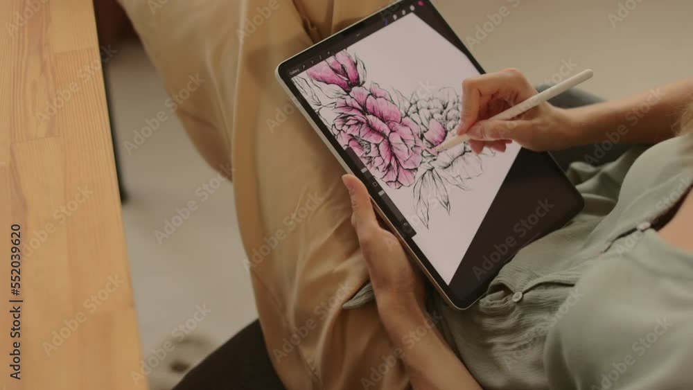 Female graphic designer working at home with digital drawing tablet and pen. Female graphic designer working at home with digital drawing tablet and pen.