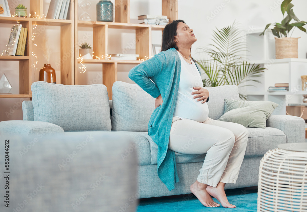 Pregnant, woman and back pain with a mother feeling painful body while sitting on her couch. Ache, inflammation and pregnancy with a maternity female with physical strain in her back at home Pregnant, woman and back pain with a mother feeling painful body while sitting on her couch. Ache, inflammation and pregnancy with a maternity female with physical strain in her back at home