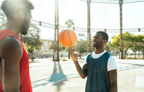 Young basketball players training at the court. Cinematic look image of friends practicing shots and slam dunks in an urban court