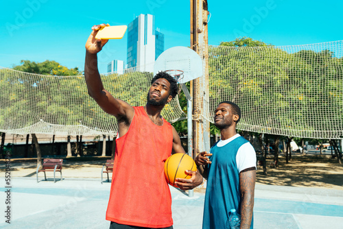 Young basketball players training at the court. Cinematic look image of friends practicing shots and slam dunks in an urban court