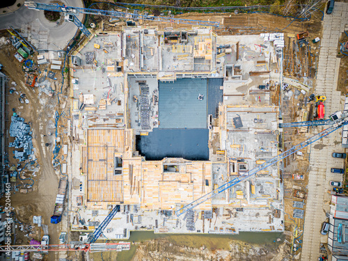 Aerial view of construction site with crane and building. Top view of big development construction and architecture. © netsay