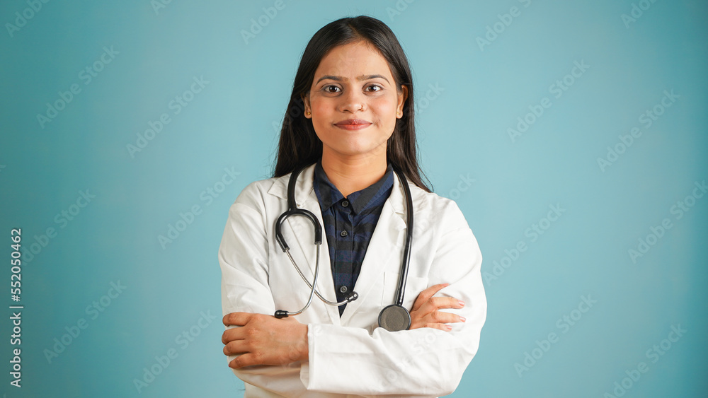 Portrait of a young female doctor wearing apron and stethoscope, Cheerful Asian Indian woman doctor isolated over blue studio background Portrait of a young female doctor wearing apron and stethoscope, Cheerful Asian Indian woman doctor isolated over blue studio background