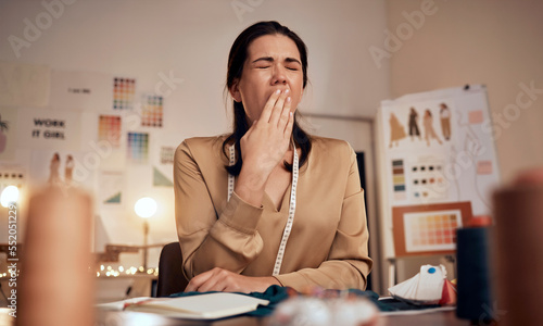 Tired fashion designer, woman and yawn while working at night in creative office, textile studio or startup. Exhausted, sleepy and overworked tailor yawning in burnout, stress and fatigue in workshop photo