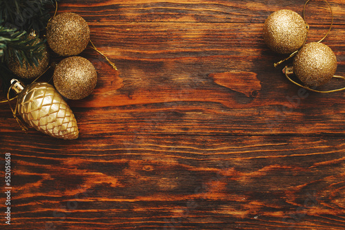 Gold Christmas balls and toys on a wooden background
