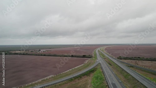 AERIAL - Completely empty highway next to fields, cloudy day, Reynosa, Tamaulipas, Mexico photo