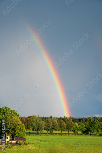part of a rainbow over green landscape