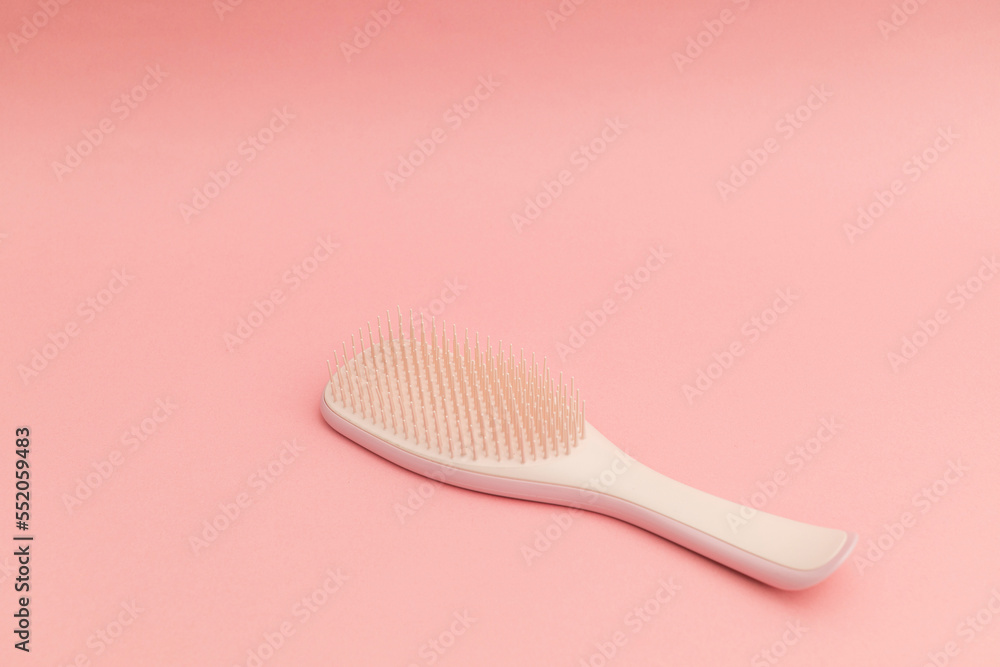Pink hairbrush on pink background, monochrome