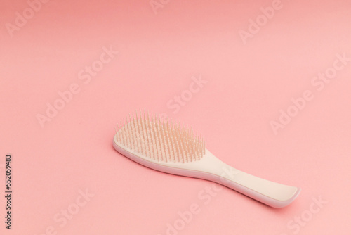 Pink hairbrush on pink background, monochrome