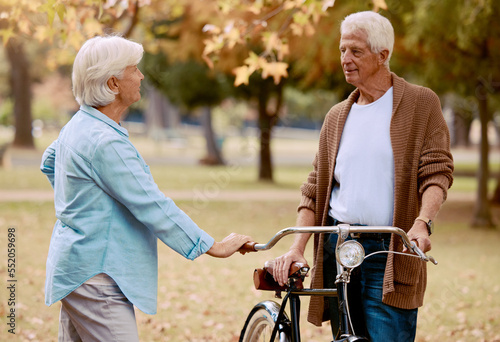 Love, bike and park with a senior couple on a date together during summer while enjoying retirement. Nature, dating and romance with a mature man and woman outdoor in a garden for bicycle bonding