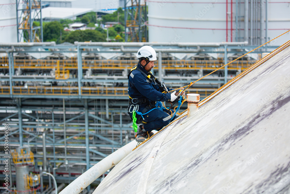 Naklejka premium Male workers clear rope access wearing safety first harness rope safety