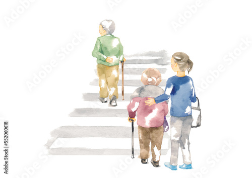 横断歩道を渡る高齢者と付添う女性