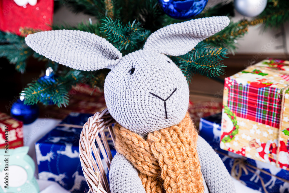 knitted elk. cute moose. toy against the background of a New Year's garland, knitted hare and elk on a Christmas tree