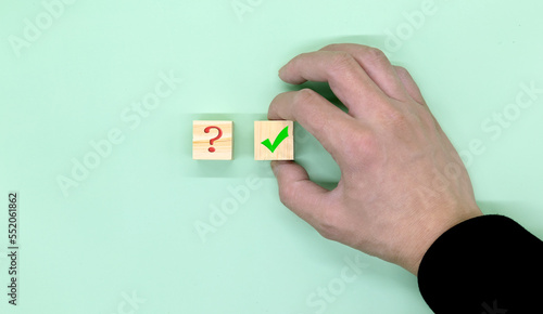 Hand making a choice between two cubes with Yes and No on neutral background.