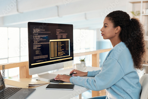 Serious female software developer working on computer in office of IT company