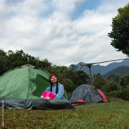 Mujer en pijama acampando y tomando aire fresco sobre el Parque Nacional Farallones de Cali, Colombia.