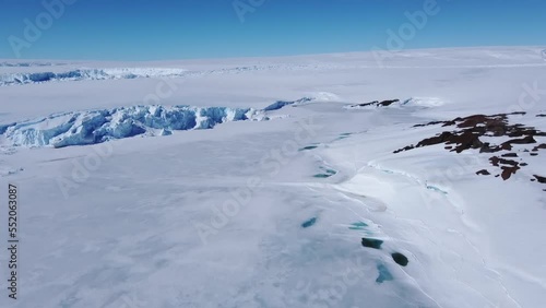 Snow covered antarctic surface aerial view flight. Desert white land of snow and ice drone shot. Frozen south pole. 