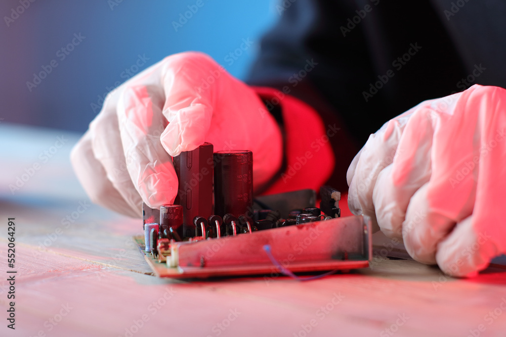 inserting a capacitor into a printed circuit board by a person Stock
