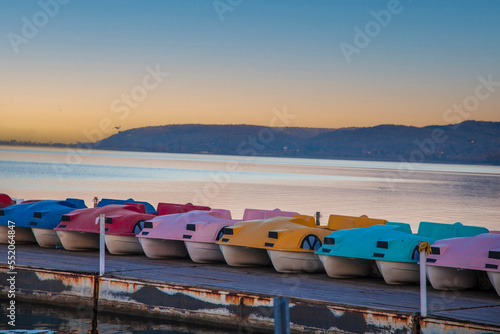 sunset over the lake, colorful lake bikes. pedalo. photo