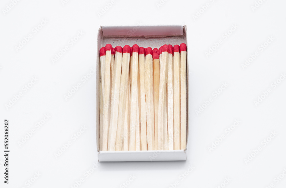 Set of new unlit matchsticks in a cardboard box on white background
