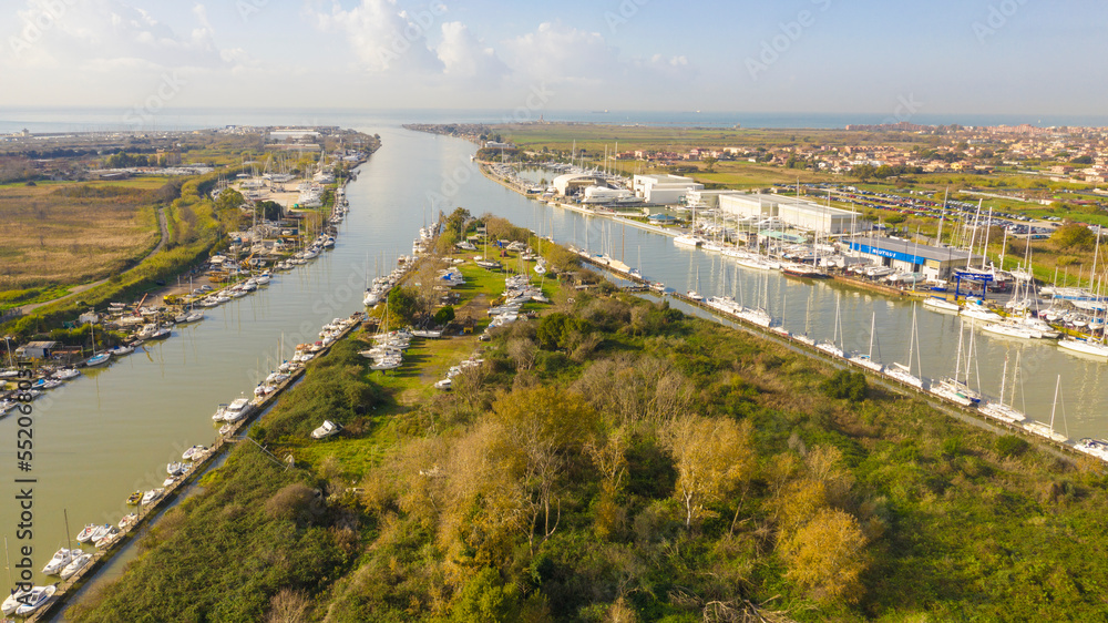 Aerial view on the Holy Isle located in Fiumicino, Italy. It' s an artificial island on the Tiber River, near Rome. Many boats are anchored. Aerial view on the Holy Isle located in Fiumicino, Italy. It' s an artificial island on the Tiber River, near Rome. Many boats are anchored.