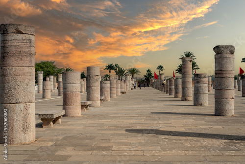 People walking around the medieval columns next to the Hassan tower in Rabat, Morocco photo