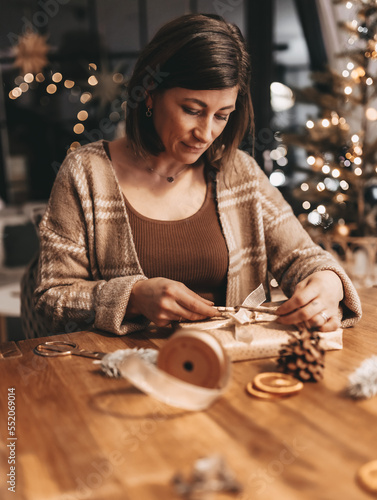 Good mood woman in a cozy environment wrapping gifts for Christmas  stylish decoration  vintage  warm colors