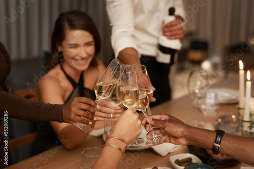Party, group of friends and celebration with champagne, New Years and cheerful together. Young people, toast and glasses to relax, dinner and happiness at event, smile and alcohol for fun and happy.