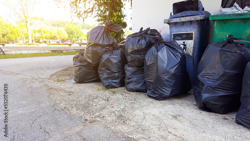 Black plastic garbage bags on the ground waiting for recycle