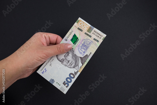 500 hryvnia female in a hand on a black