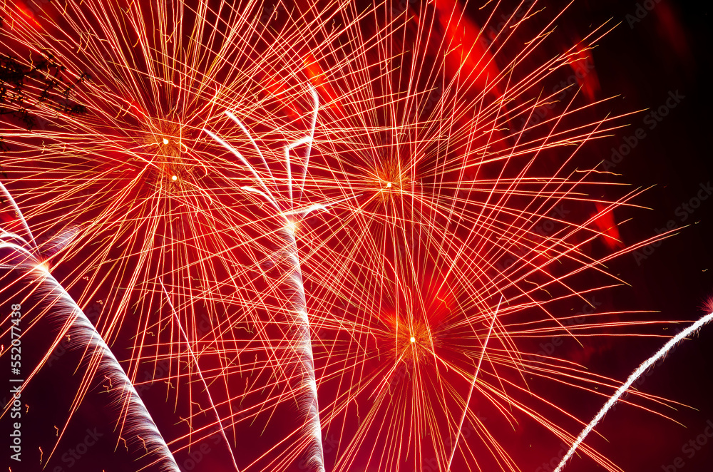 Fototapeta premium Abstract background - bright beams of festive colorful fireworks against black night sky.