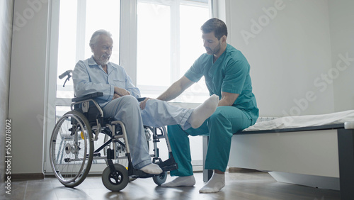 Professional physical therapist helping elderly man to do exercise  mobility