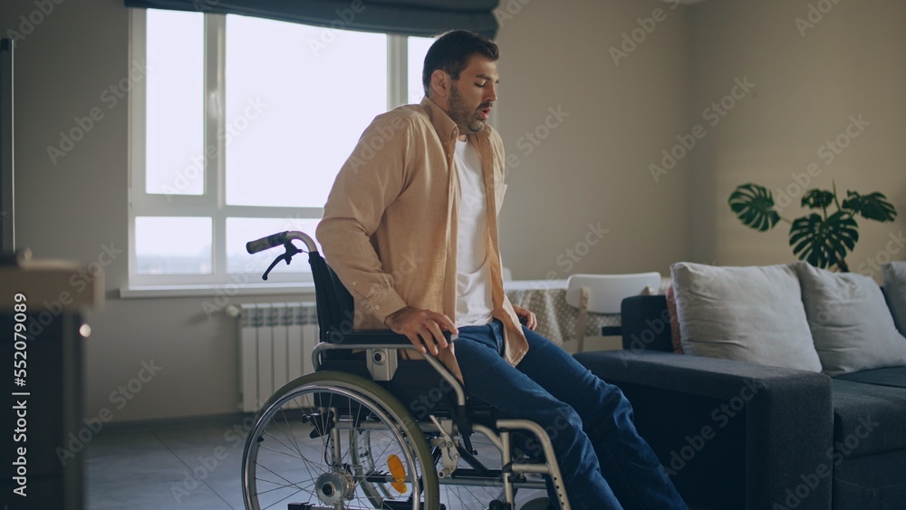 Man trying to get up from wheelchair, recovery after injury, rehabilitation Man trying to get up from wheelchair, recovery after injury, rehabilitation
