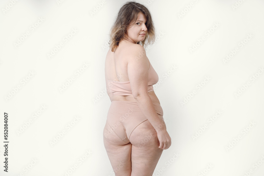 Portrait of a young beautiful plump woman posing in underwear, isolated on gray. Concept of beauty, body and skin care, body positive. Portrait of a young beautiful plump woman posing in underwear, isolated on gray. Concept of beauty, body and skin care, body positive.