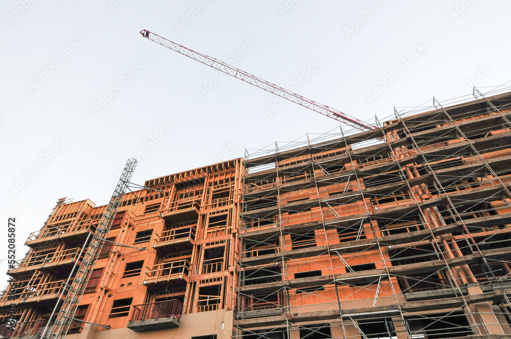 Scaffolding on multi-storey commercial building under construction Scaffolding on multi-storey commercial building under construction
