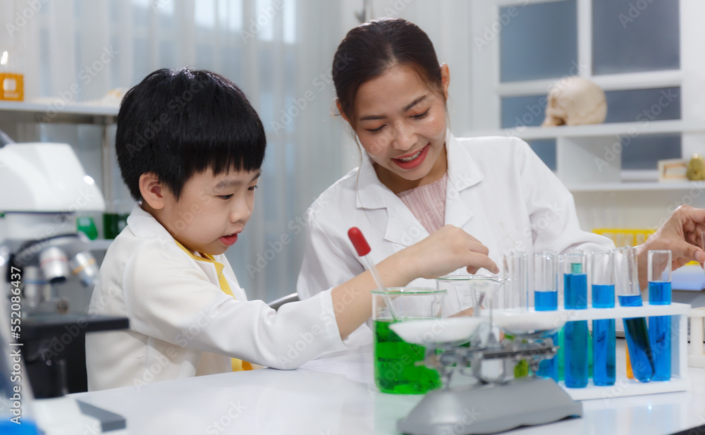 Asian boy and female teacher learn to experiment with mixing liquids in tubes. Science Asian boy and female teacher learn to experiment with mixing liquids in tubes. Science