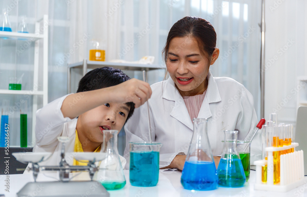 Asian boy and female teacher learn to experiment with mixing liquids in tubes. Science Asian boy and female teacher learn to experiment with mixing liquids in tubes. Science